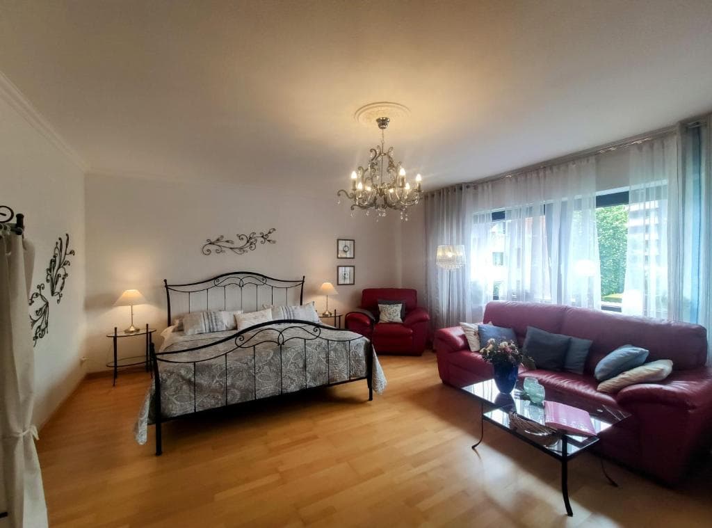 Erholungs Apartment - Schlafzimmer mit Metallbett und gemütlicher Sitzecke